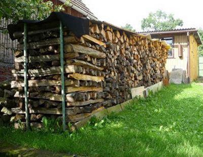 Укрепить поленницу можно вертикально вбитыми трубами или арматурой